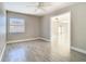 Bright bedroom with a ceiling fan, wood-look tile flooring, and views into a living area at 11364 Cardiff Dr, Orlando, FL 32837