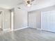 A well-lit bedroom featuring tile flooring, neutral walls, a ceiling fan, and double closets at 11364 Cardiff Dr, Orlando, FL 32837