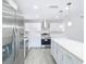 Updated kitchen featuring stainless steel appliances, white cabinets, quartz countertops, and modern lighting fixtures at 11364 Cardiff Dr, Orlando, FL 32837
