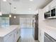 Bright, open kitchen featuring a center island, stainless steel appliances, and sliding doors to the backyard pool area at 11364 Cardiff Dr, Orlando, FL 32837