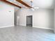 Bright living room with vaulted ceilings, wooden beams, light-colored walls, and tile flooring at 11364 Cardiff Dr, Orlando, FL 32837