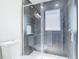 Modern shower with gray tiling, a glass enclosure, and a recessed shelf for toiletries at 11364 Cardiff Dr, Orlando, FL 32837