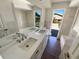 Bathroom features a double sink vanity with a large mirror and natural light streaming through the windows at 1155 Galahad Dr, Casselberry, FL 32707