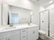 Bright bathroom with double vanity, quartz countertop, and glass-enclosed shower at 13820 Adams St, Grand Island, FL 32735