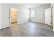 Bedroom featuring wood-look floors, a window, and an ensuite bathroom at 13820 Adams St, Grand Island, FL 32735