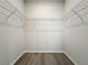 Walk-in closet with installed shelving and wood-look floors at 13820 Adams St, Grand Island, FL 32735
