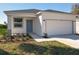 A charming house exterior featuring a beautiful lawn, fresh landscaping, and an attached two-car garage at 13820 Adams St, Grand Island, FL 32735