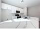 Bright kitchen with white cabinets, stainless steel appliances, and sleek countertops at 13820 Adams St, Grand Island, FL 32735