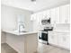 Modern kitchen featuring white cabinets, marble counters, and stainless steel appliances at 13820 Adams St, Grand Island, FL 32735
