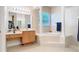 Bright bathroom with a soaking tub, columns, tile floor, vanity with makeup counter, and a large mirror at 1421 Arbitus Cir, Oviedo, FL 32765