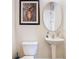 Well-lit bathroom with pedestal sink, toilet, and framed artwork at 1421 Arbitus Cir, Oviedo, FL 32765