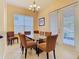 Dining room with a modern glass top table, seating for six and a window with light pouring in at 1421 Arbitus Cir, Oviedo, FL 32765