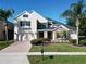 Two-story home featuring a lush, landscaped front yard, stone accents and a brick driveway at 1421 Arbitus Cir, Oviedo, FL 32765