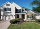 Beautiful two-story home with a brick driveway, stone accents, manicured lawn, and palm trees at 1421 Arbitus Cir, Oviedo, FL 32765