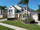 Inviting two-story home with manicured lawn, stone accents, and brick-paved driveway and sidewalks at 1421 Arbitus Cir, Oviedo, FL 32765