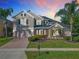 A two-story home with brick driveway and manicured lawn, bathed in the warm glow of sunset at 1421 Arbitus Cir, Oviedo, FL 32765