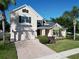 A beautiful two-story home with a brick driveway and attached two-car garage with green shutters at 1421 Arbitus Cir, Oviedo, FL 32765