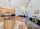 Spacious kitchen featuring granite countertops, light wood cabinetry, and an open design to the dining area at 1421 Arbitus Cir, Oviedo, FL 32765