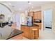 Bright kitchen with wood cabinets, black countertops, stainless appliances, and center island at 1421 Arbitus Cir, Oviedo, FL 32765