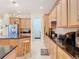 Well-equipped kitchen with wood cabinets, granite countertops, and stainless steel appliances at 1421 Arbitus Cir, Oviedo, FL 32765