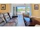Bright living room with tan walls, a comfy brown couch and view of screened-in patio at 1421 Arbitus Cir, Oviedo, FL 32765