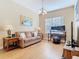 Bright living room with natural light, a couch, a desk with monitors, and wood flooring at 1421 Arbitus Cir, Oviedo, FL 32765