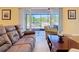 Cozy living room features a sliding glass door to the screened patio and comfortable seating at 1421 Arbitus Cir, Oviedo, FL 32765