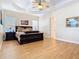 Spacious main bedroom featuring a tray ceiling, fan, wood floors, a dark wood bed, and windows with blinds at 1421 Arbitus Cir, Oviedo, FL 32765