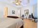 Spacious main bedroom featuring a tray ceiling, fan, wood floors, a dark wood bed, and open doorways at 1421 Arbitus Cir, Oviedo, FL 32765