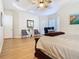 Large primary bedroom with hardwood floors, a sitting area, and a tray ceiling at 1421 Arbitus Cir, Oviedo, FL 32765