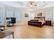 Spacious main bedroom featuring a tray ceiling, fan, wood floors, and a work space with desk and chairs at 1421 Arbitus Cir, Oviedo, FL 32765