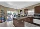 Lovely kitchen with island, pendant lights, granite counters, view to screened patio, and stainless appliances at 14266 Squirrel Run, Orlando, FL 32828