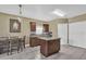 Eat-in kitchen features an island, warm wood cabinets, granite counters, and pendant lighting at 14266 Squirrel Run, Orlando, FL 32828