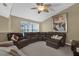 Inviting living room featuring plush leather seating, a ceiling fan, and large art piece at 14266 Squirrel Run, Orlando, FL 32828