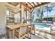 Outdoor dining area featuring a wooden table and seating with a view of the screened-in pool at 14266 Squirrel Run, Orlando, FL 32828