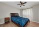 Cozy bedroom featuring a ceiling fan, wood-look flooring, a bed, and a nightstand at 14617 Keelford Way, Orlando, FL 32824