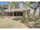 An open backyard with a screened-in porch and mature trees, providing a comfortable outdoor living space at 1570 Farrindon Cir, Lake Mary, FL 32746