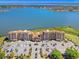 Expansive aerial view showcasing luxury condominiums next to a serene lake, parking, and green spaces at 16300 County Road 455 # 401, Montverde, FL 34756