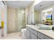 Modern bathroom boasts marble floors, sliding glass door shower and grey vanity with plenty of counter space at 16300 County Road 455 # 401, Montverde, FL 34756
