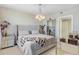 Bright bedroom featuring a plush upholstered bed, mirrored accents, and elegant lighting at 16300 County Road 455 # 401, Montverde, FL 34756