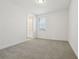 Cozy bedroom showcasing neutral carpeting, white walls, and natural lighting from a window at 16354 Silver Grove Blvd, Winter Garden, FL 34787
