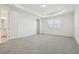 Spacious carpeted bedroom featuring tray ceilings, natural light, and a door to the bathroom at 16354 Silver Grove Blvd, Winter Garden, FL 34787