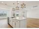 Bright kitchen features a center island with white countertops and cabinets and contemporary pendant lighting at 16354 Silver Grove Blvd, Winter Garden, FL 34787