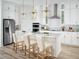 Modern white kitchen featuring stainless steel appliances, marble backsplash, and a center island with seating at 16354 Silver Grove Blvd, Winter Garden, FL 34787
