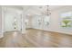 Spacious living room featuring an elegant light fixture, bright natural light, and hardwood floors at 16354 Silver Grove Blvd, Winter Garden, FL 34787