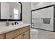 Modern bathroom features black fixtures, a large mirror, and a shower with sleek sliding glass doors at 17300 Pesce Loop, Montverde, FL 34756