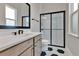 Modern bathroom featuring black and white floors, glass shower and light wood vanity at 17300 Pesce Loop, Montverde, FL 34756