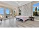 Bedroom featuring light wood floors, tray ceiling, a statement wall and patio access at 17300 Pesce Loop, Montverde, FL 34756