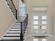 Entryway with white stairs featuring black trim and a door with glass panels at 17300 Pesce Loop, Montverde, FL 34756