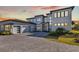 Modern home boasts a beautiful stone driveway, manicured lawn, and a three-car garage at 17300 Pesce Loop, Montverde, FL 34756